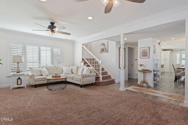 living room featuring crown molding, ceiling fan, carpet floors, and decorative columns