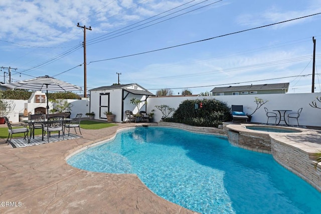 view of swimming pool with exterior fireplace, a patio area, an outdoor structure, and an in ground hot tub