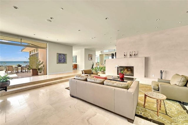 living room with a fireplace, expansive windows, and a water view