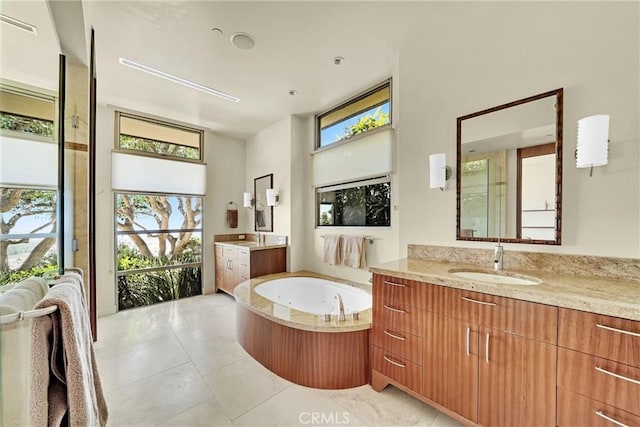 bathroom featuring vanity, a washtub, and tile patterned floors