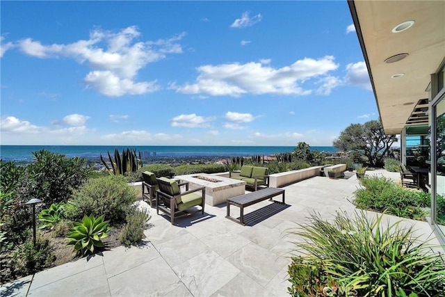 view of patio / terrace with an outdoor living space with a fire pit and a water view