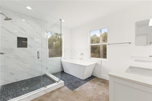 bathroom with vanity, independent shower and bath, and tile walls