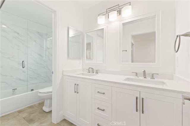 full bathroom with vanity, bath / shower combo with glass door, and toilet