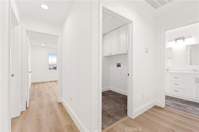 hallway featuring sink and light wood-type flooring