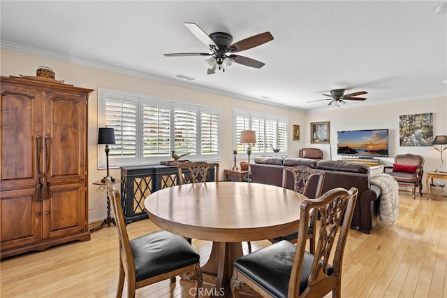 dining area with ceiling fan, ornamental molding, and light wood-type flooring