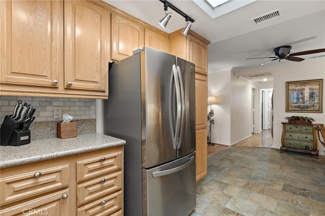 kitchen featuring light brown cabinetry, stainless steel fridge, decorative backsplash, ceiling fan, and crown molding