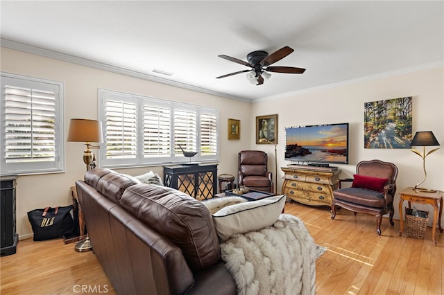 living room with ornamental molding and light hardwood / wood-style flooring