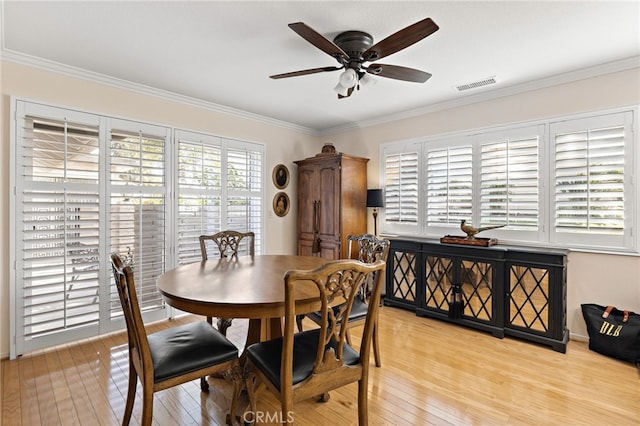 dining room featuring ornamental molding, ceiling fan, and light wood-type flooring