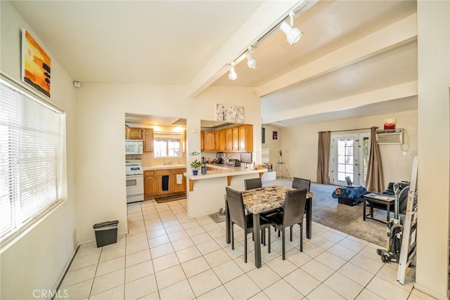 dining room featuring rail lighting, sink, vaulted ceiling with beams, a wall mounted AC, and light tile patterned floors