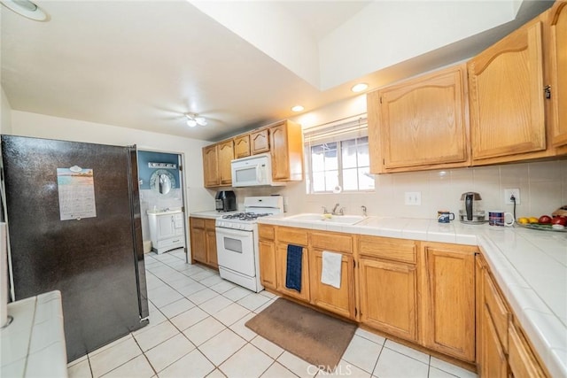 kitchen featuring white appliances, ceiling fan, tasteful backsplash, tile counters, and light tile patterned flooring