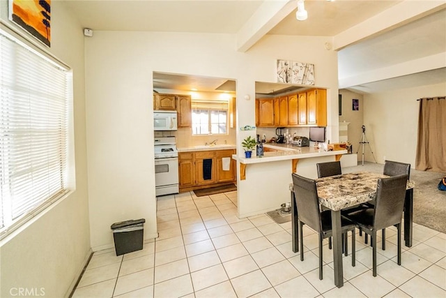 kitchen with vaulted ceiling with beams, light tile patterned floors, white appliances, and kitchen peninsula