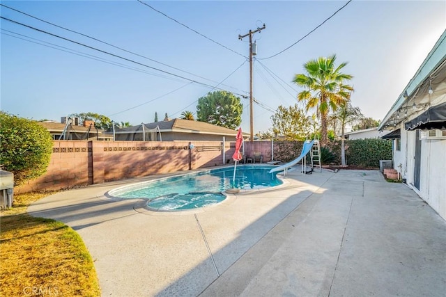 view of pool with a water slide and a patio area