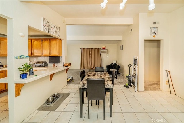 dining area featuring light tile patterned flooring and an AC wall unit