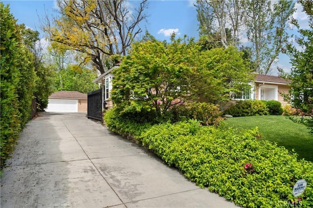 view of property exterior with a garage, an outdoor structure, and a lawn