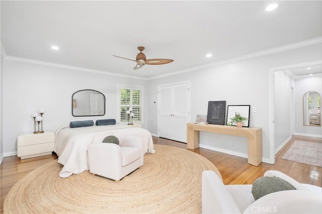 bedroom with ornamental molding, hardwood / wood-style floors, and ceiling fan