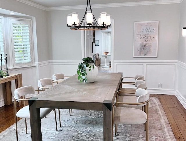 dining area with an inviting chandelier, hardwood / wood-style flooring, and ornamental molding