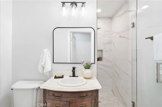 bathroom with vanity, toilet, and a shower with shower door