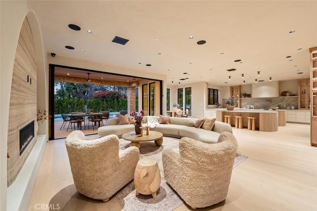 living room with a fireplace and light wood-type flooring