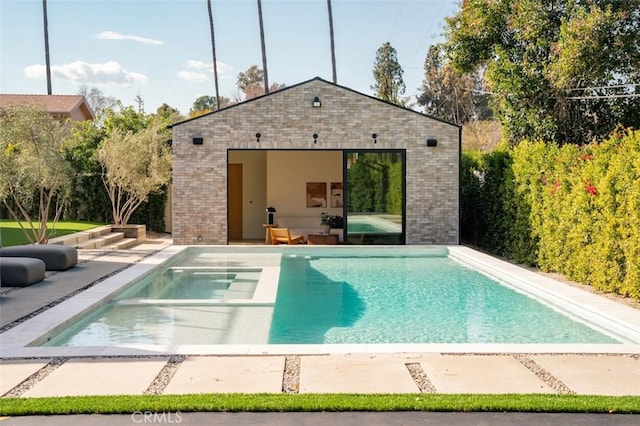 pool featuring a patio area, an exterior structure, and an outbuilding