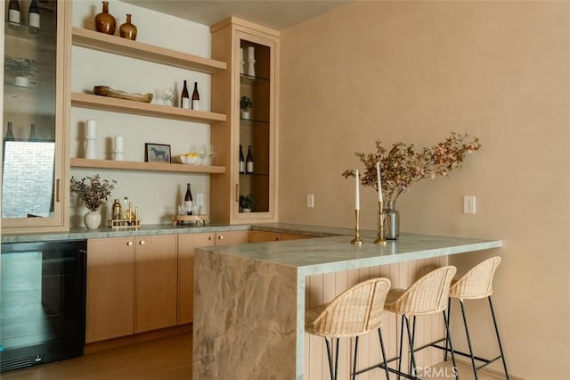 bar featuring wine cooler and light hardwood / wood-style floors