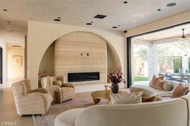 living room with a fireplace and light wood-type flooring