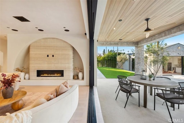 view of patio / terrace with ceiling fan and an outdoor fireplace