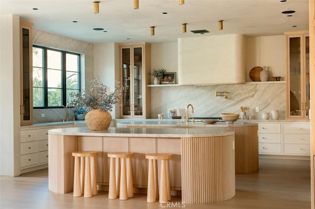 kitchen with a kitchen island, sink, backsplash, and a kitchen breakfast bar