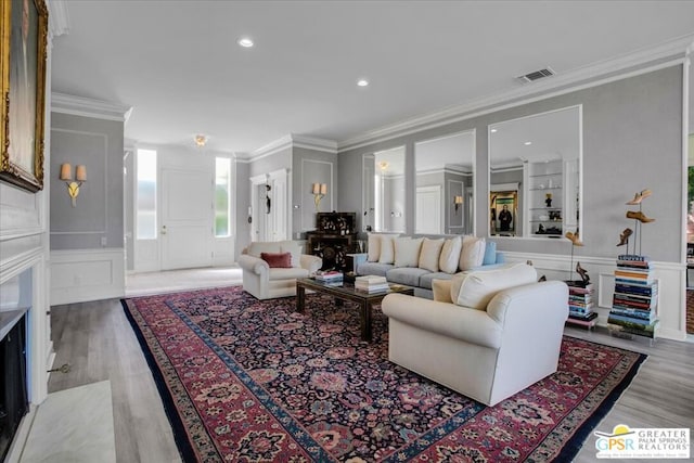 living room with crown molding and light hardwood / wood-style floors