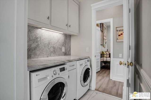 clothes washing area featuring cabinets and independent washer and dryer