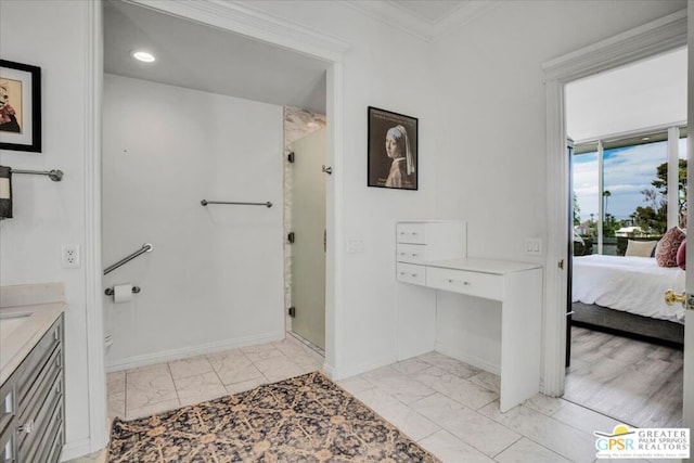 bathroom with vanity, ornamental molding, and walk in shower