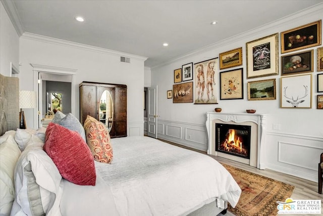 bedroom with crown molding and light hardwood / wood-style flooring