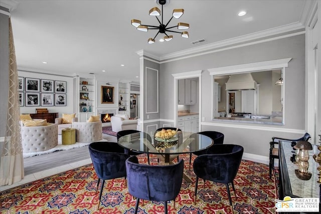 tiled dining room with crown molding, built in features, and an inviting chandelier