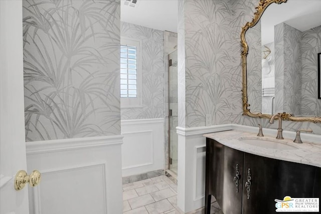 bathroom with vanity and a shower with door