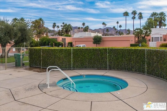 view of pool featuring a hot tub and a mountain view