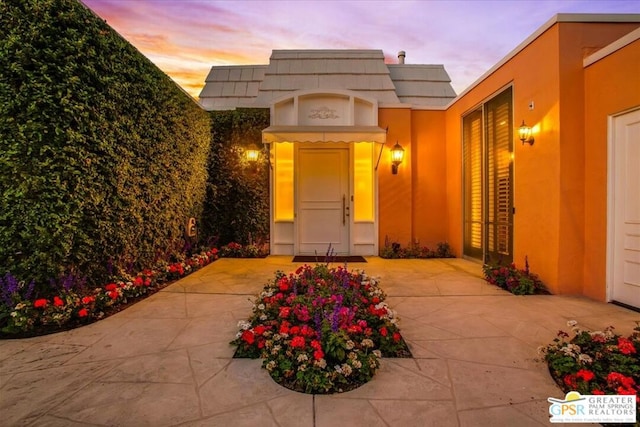 exterior entry at dusk with a patio area