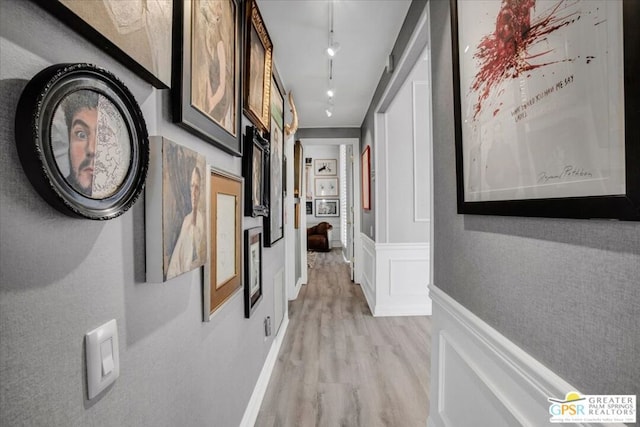 hallway with track lighting and light hardwood / wood-style floors