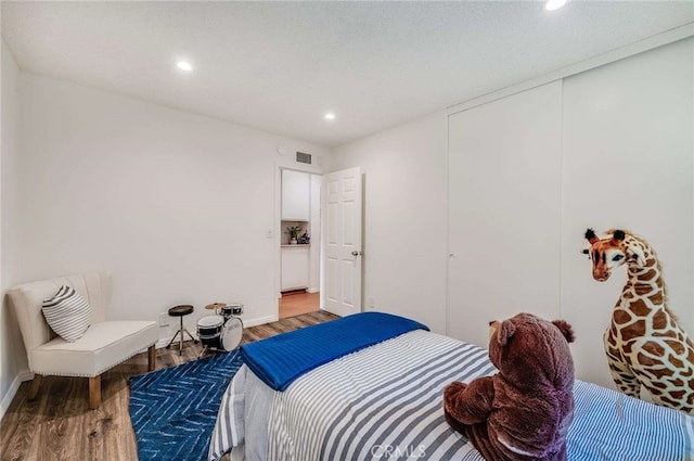 bedroom with wood-type flooring and a closet