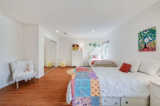 bedroom featuring hardwood / wood-style floors and a closet