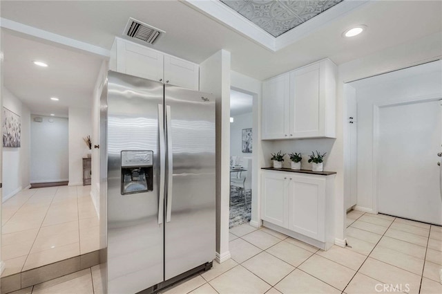 kitchen with white cabinetry, light tile patterned flooring, and stainless steel fridge