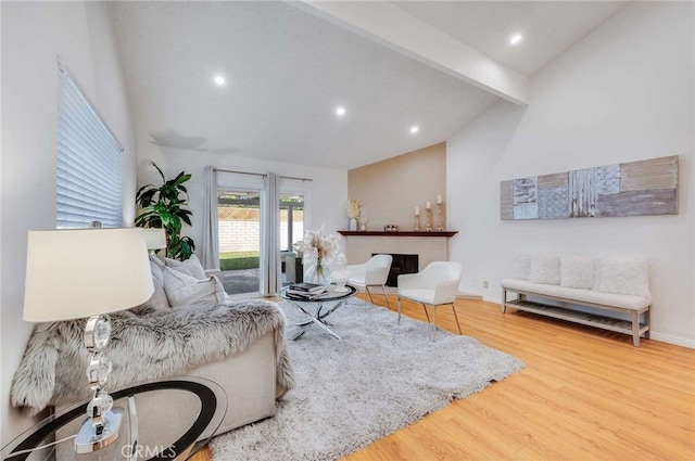 living room featuring beamed ceiling, wood-type flooring, and high vaulted ceiling