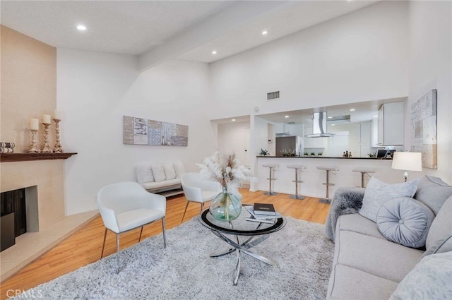 living room with a high ceiling and light wood-type flooring