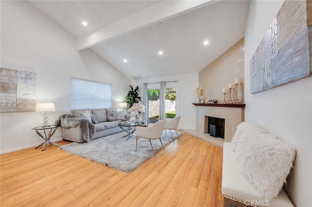 living room with high vaulted ceiling, beam ceiling, and light hardwood / wood-style flooring