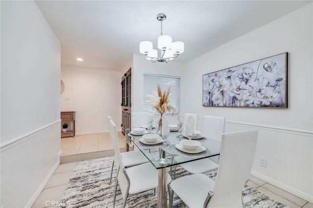 dining area with light tile patterned floors and an inviting chandelier