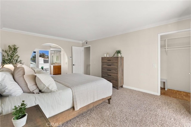 bedroom featuring a spacious closet, ornamental molding, a closet, and light parquet flooring