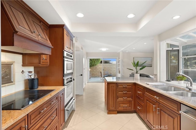 kitchen with sink, custom exhaust hood, stainless steel dishwasher, light stone countertops, and black electric cooktop