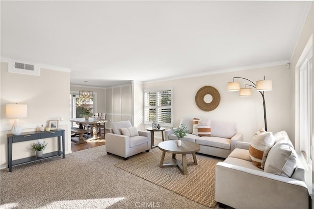 living room featuring ornamental molding, plenty of natural light, and a chandelier