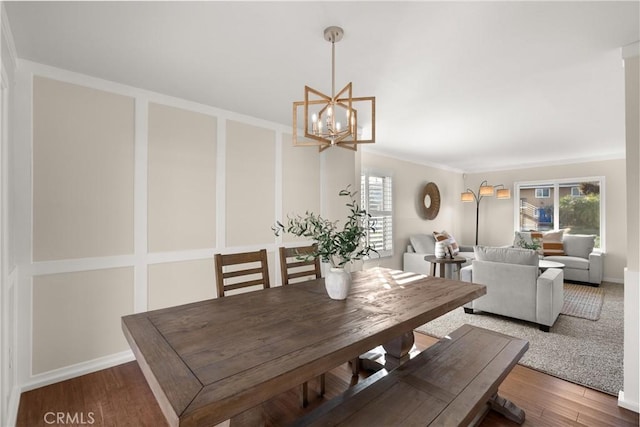 dining room featuring hardwood / wood-style flooring, ornamental molding, plenty of natural light, and a chandelier