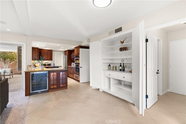 kitchen with wine cooler, stainless steel refrigerator, and light tile patterned flooring