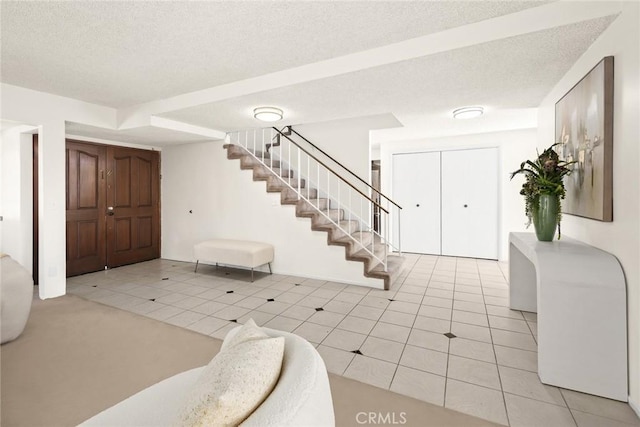 tiled foyer entrance with a textured ceiling