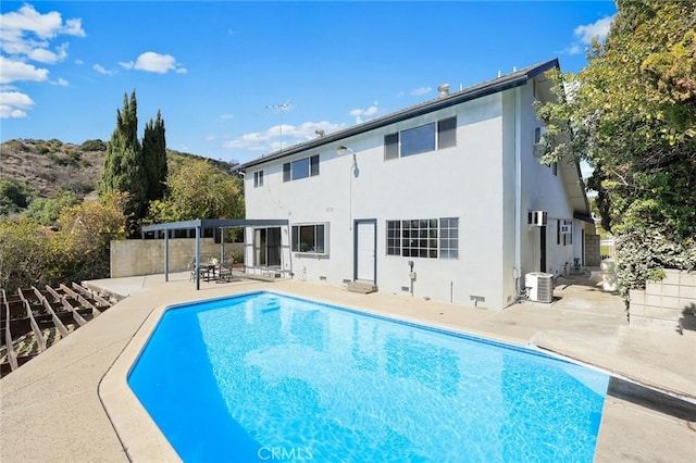 rear view of house with central AC unit and a patio